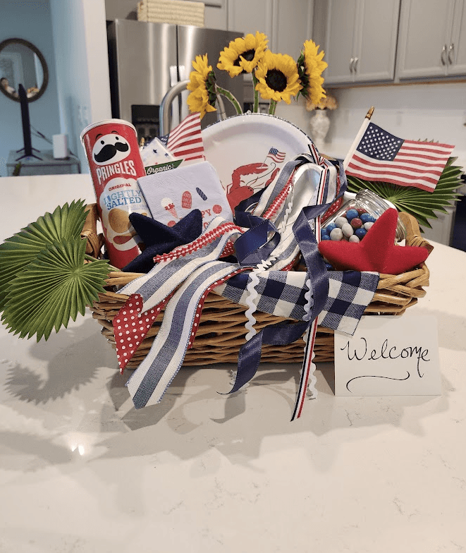 Red, white & blue welcome basket with snacks, candy, a plate, and a small American flag